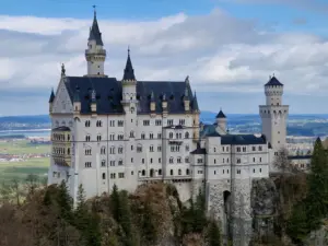 Neuschwanstein Castle with towers and turrets under a cloudy sky